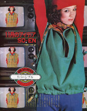 Patricia modeling a red beret and green jacket with TV's